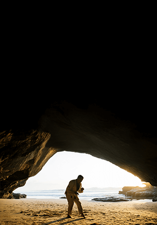 Man practicing martial arts on a beach 