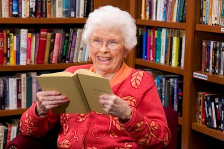 Older woman reading a book in a library