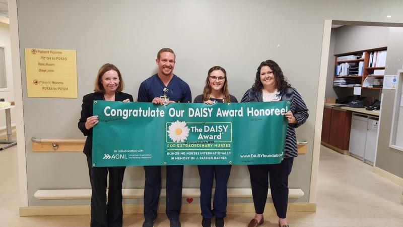 Daisy award winners holding banner