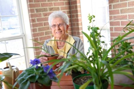 Older woman behind flower pots