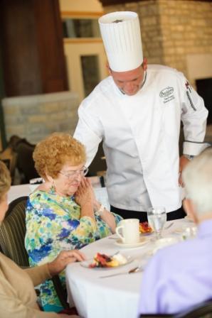 Chef serving older woman
