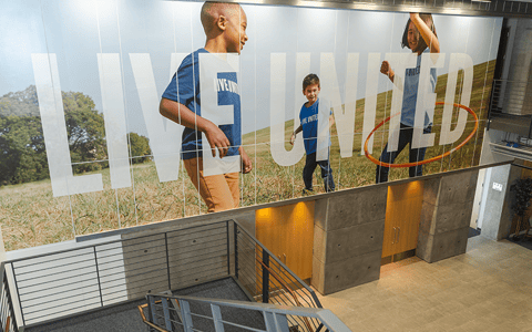 United Way sign with kids running featured in Dallas lobby.