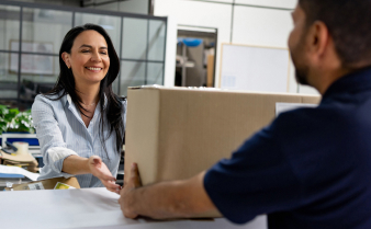 Woman receiving a business package from a delivery man.  