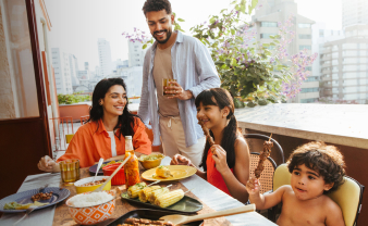 Mom and Dad enjoying an outdoor meal with their kids on a pleasant sunny day.