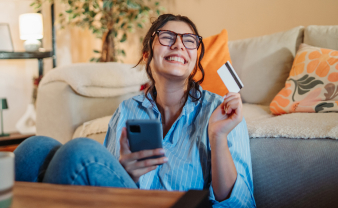 Girl smiling while holding her credit card. 