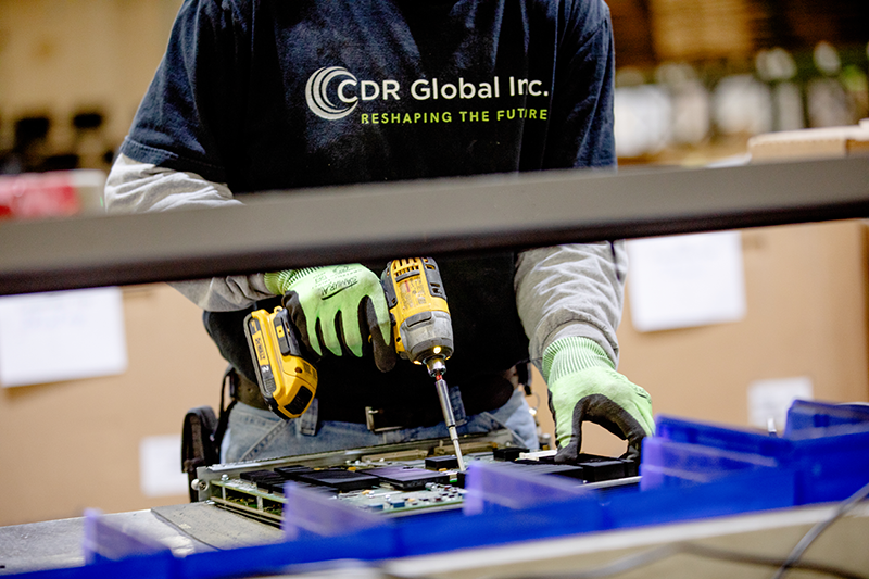 CDR Global tech working on a computer component at their facility
