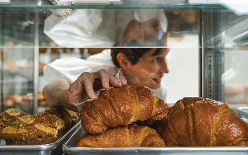 Empire Baking owner, Meaders Ozarow grabbing a croissant for a customer.