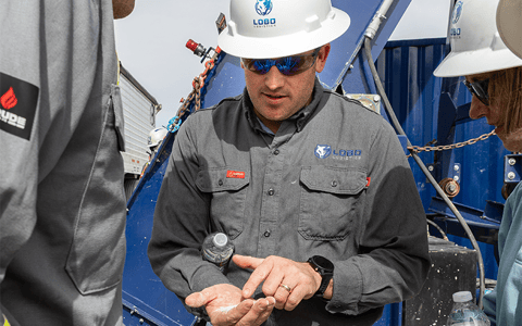 Lobo Logistics COO, Marcus Dacar sifting sand and explaning fracking process.