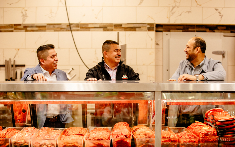 Supermercados Morelos founders behind a butcher counter