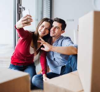 Pareja rodeada de cajas haciéndose un selfie