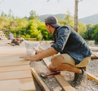 Hombre construyendo una cubierta de madera en el patio trasero