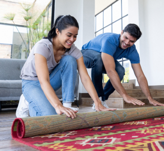 Pareja nativa americana despliegando una alfombra tribal tradicional