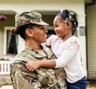 Madre militar sonriente sosteniendo a su hija