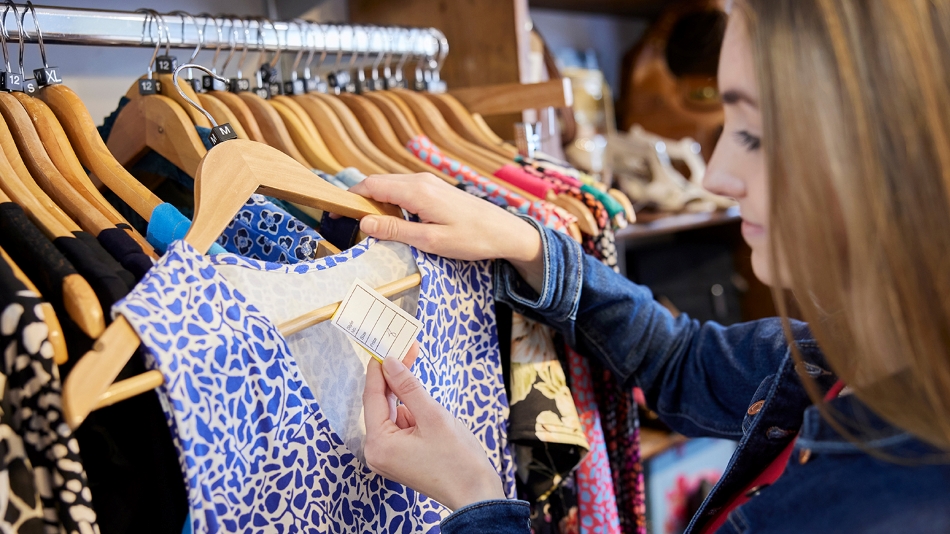 Woman shopping for clothes, reading price tag