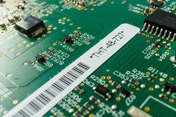Closeup of a Brady printed B727 PCB label on a circuit board.