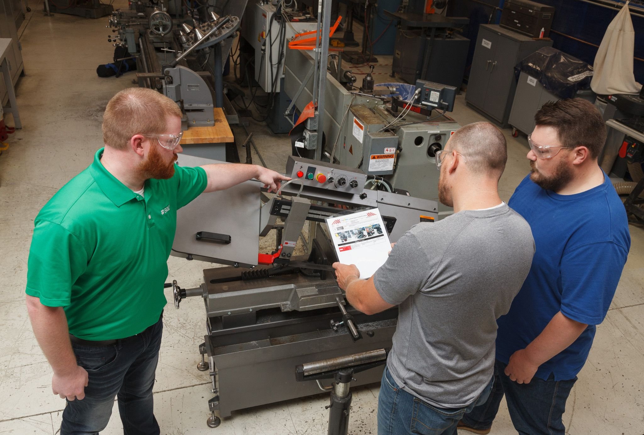 Three employees review lockout tagout procedures.