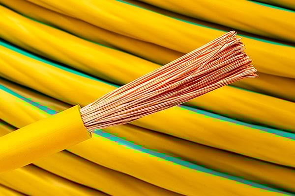 Yellow and green electrical wire with exposed copper strands.