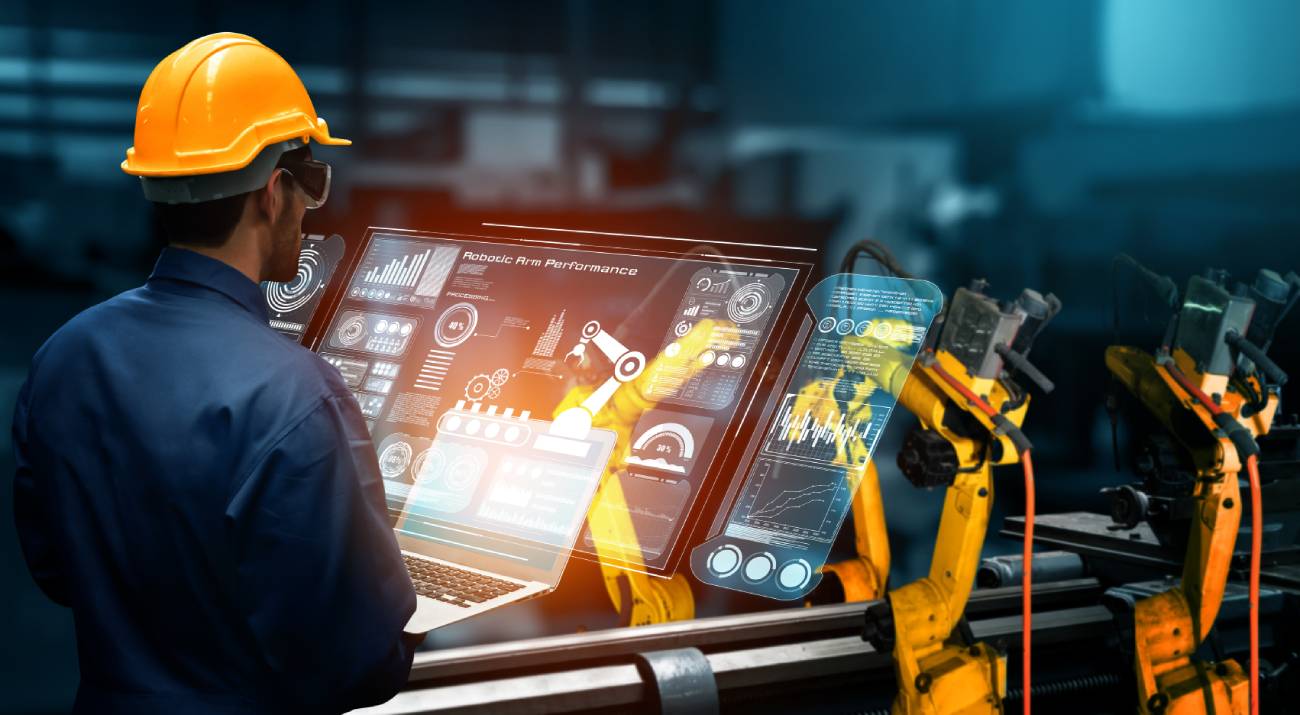 Man with screens in front of him and robot arm on the side