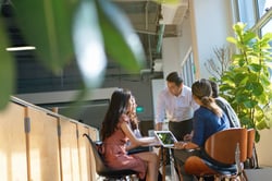 Gruppe Menschen am Schreibtisch mit Laptop