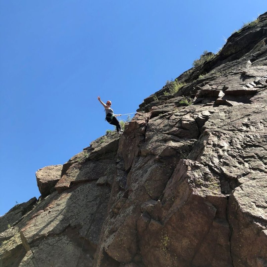 Katie Rossman climbing a rock outdoors