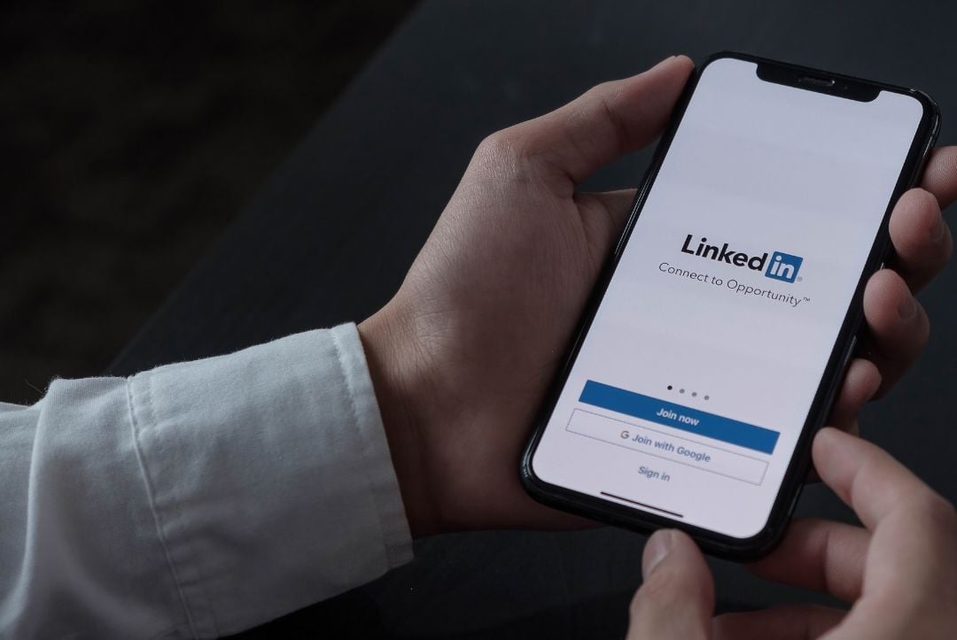 Man holding iphone and logging in to LinkedIn