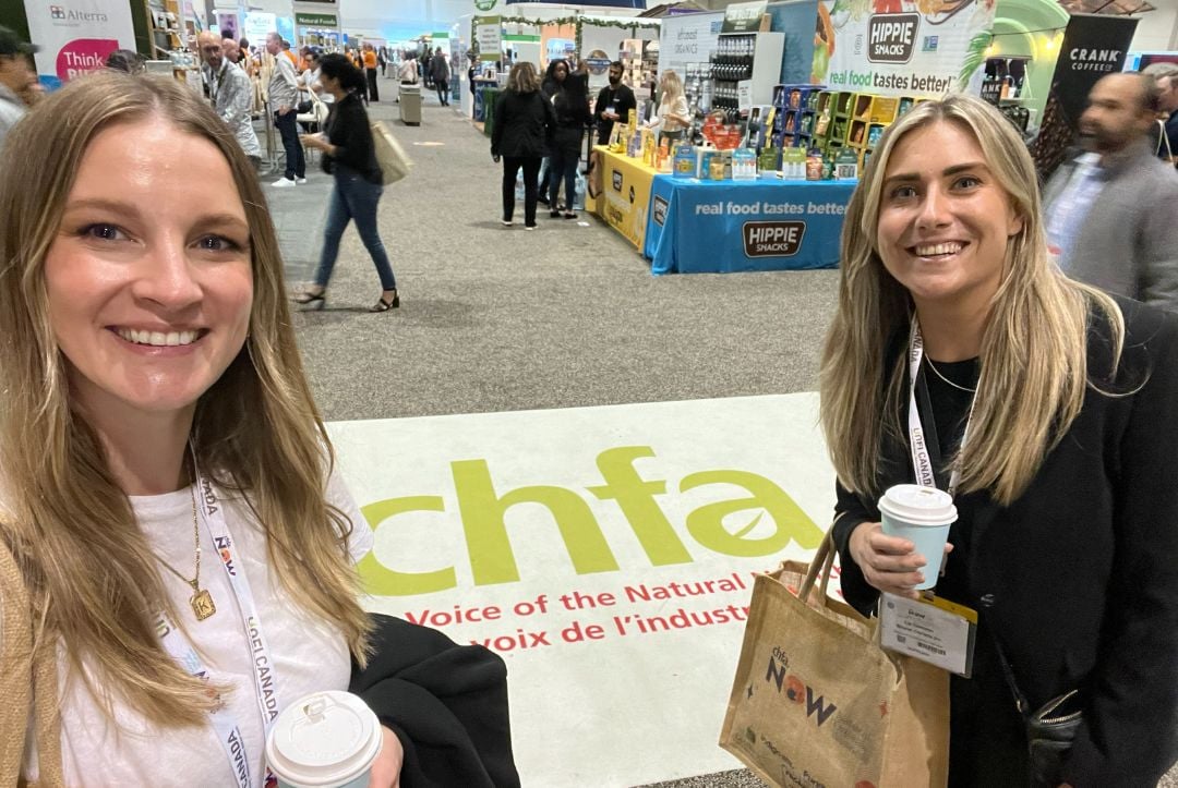 Women pose in front of large floor sign at CHFA NOW conference