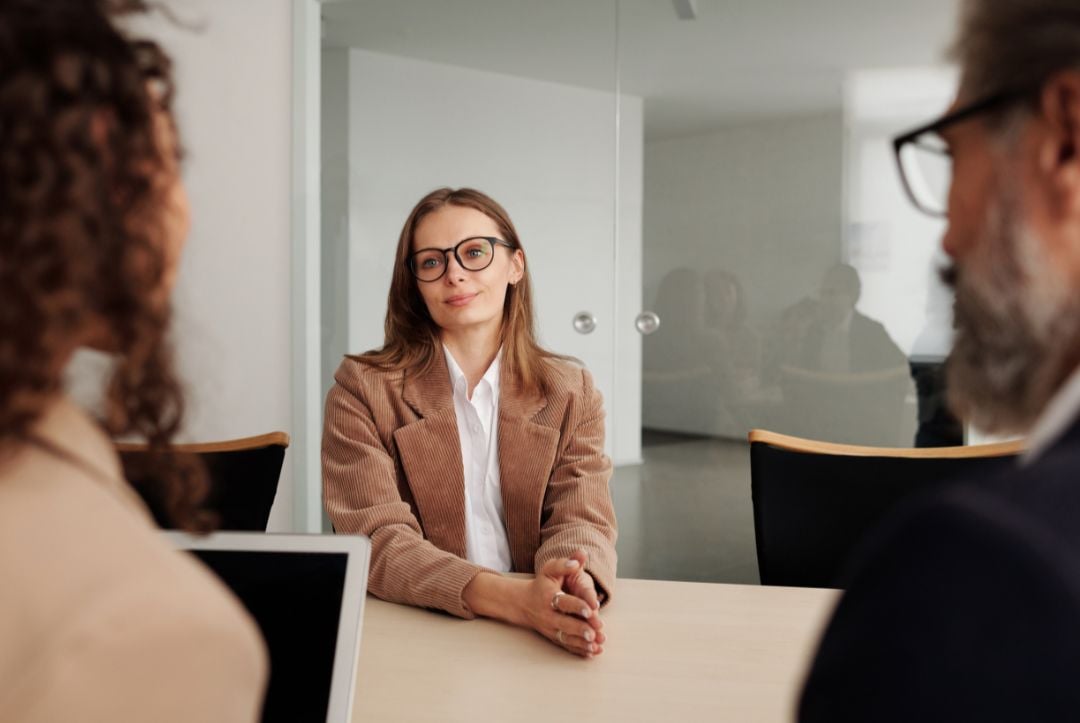 Woman sits for job interview with two recruitment professionals