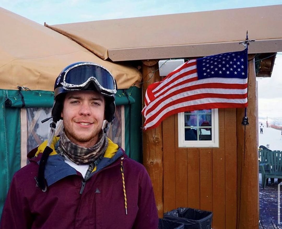 David Bonno at a ski resort pictured in front of an American flag