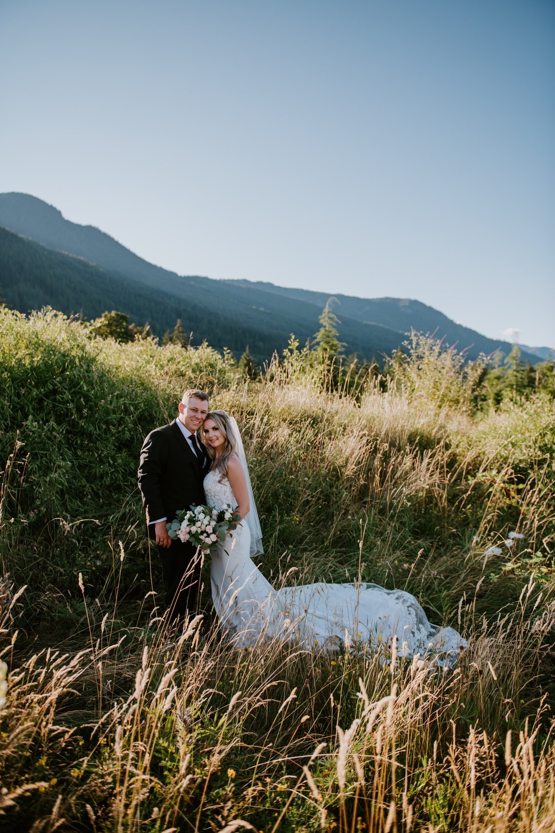 Donovan Coones and his wife on their wedding day standing on a hillside.