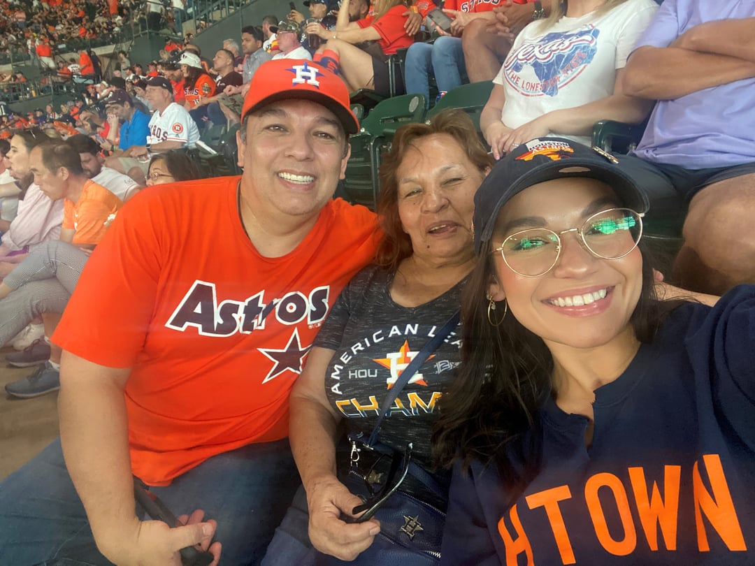 Family of 3 taking a selfie while attending a Houston Astros baseball game together