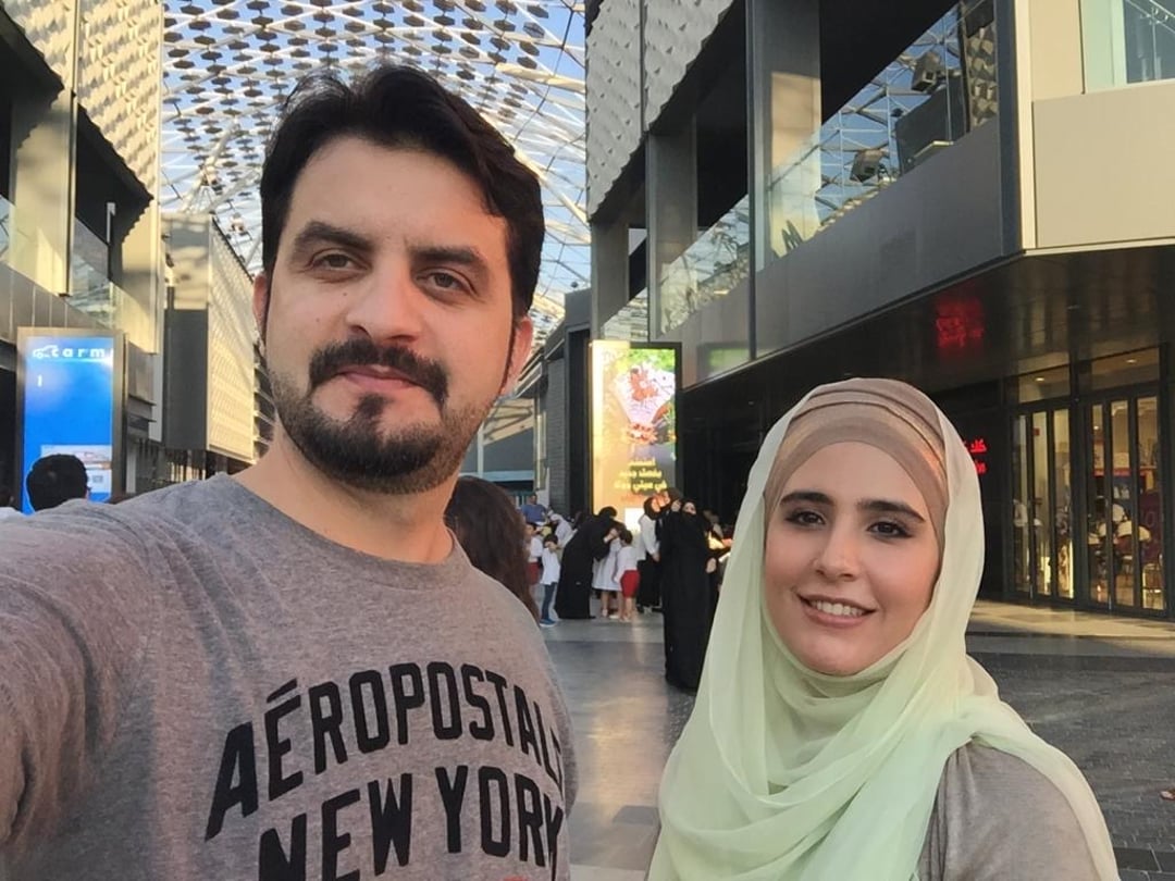 Bearded man taking selfie with woman wearing hijab in Dubai