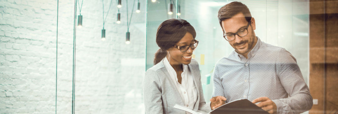 Black woman and white man discussing documents in an office