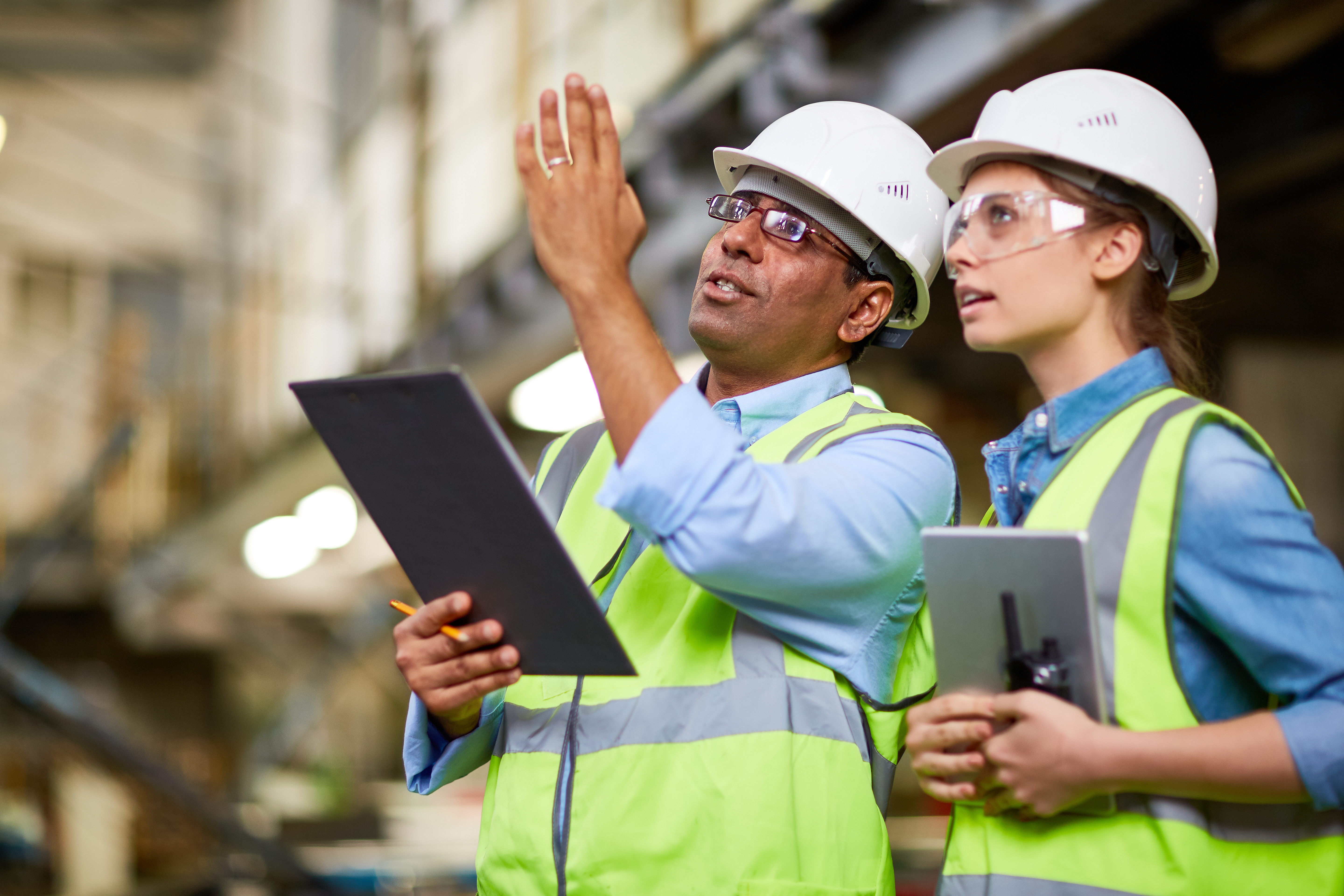 Male and female_hardhats discussing project