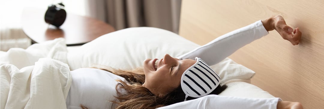 Woman stretching happily after a good night's sleep
