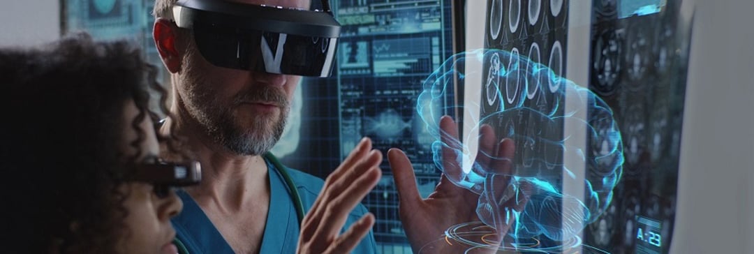 two medical professionals looking at a hologram of brain using VR
