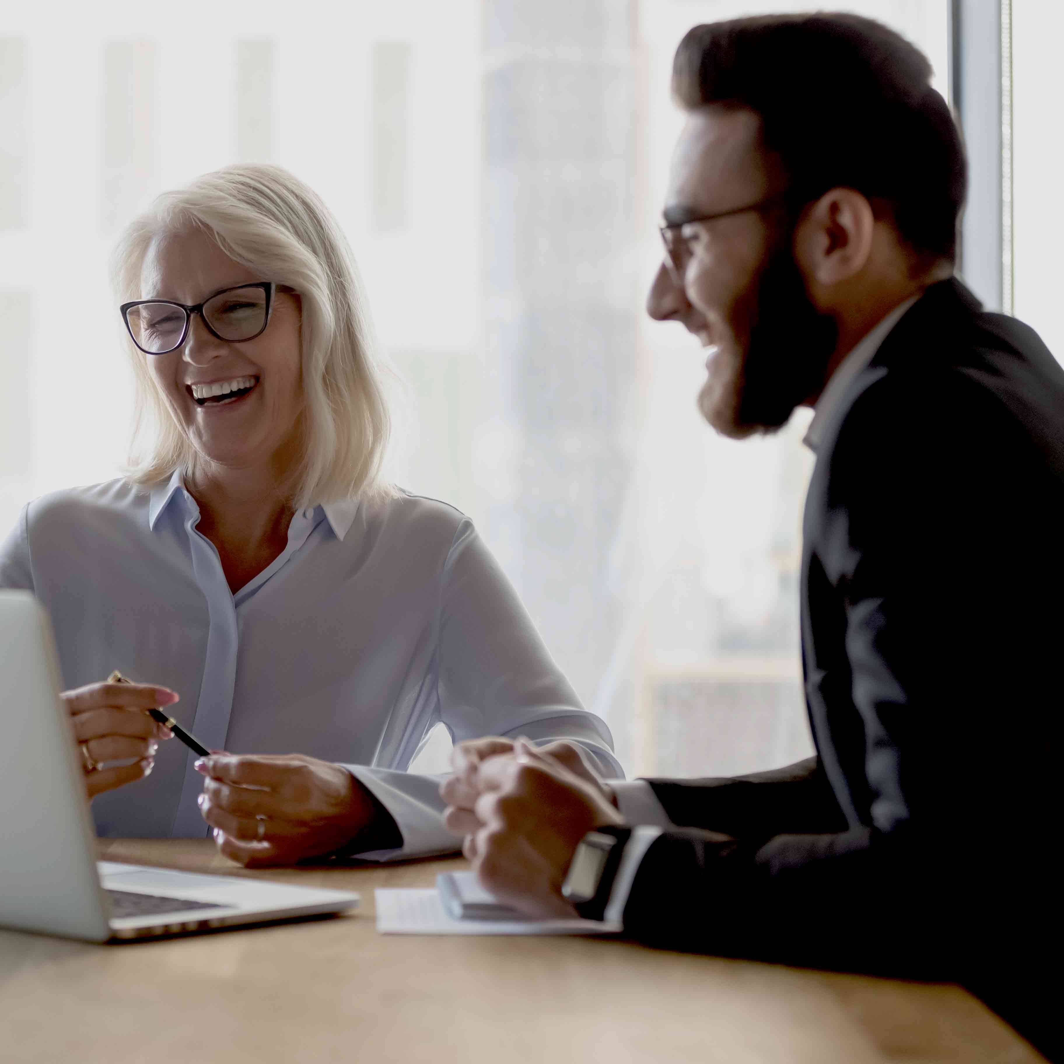 Two business people talking over plans in office