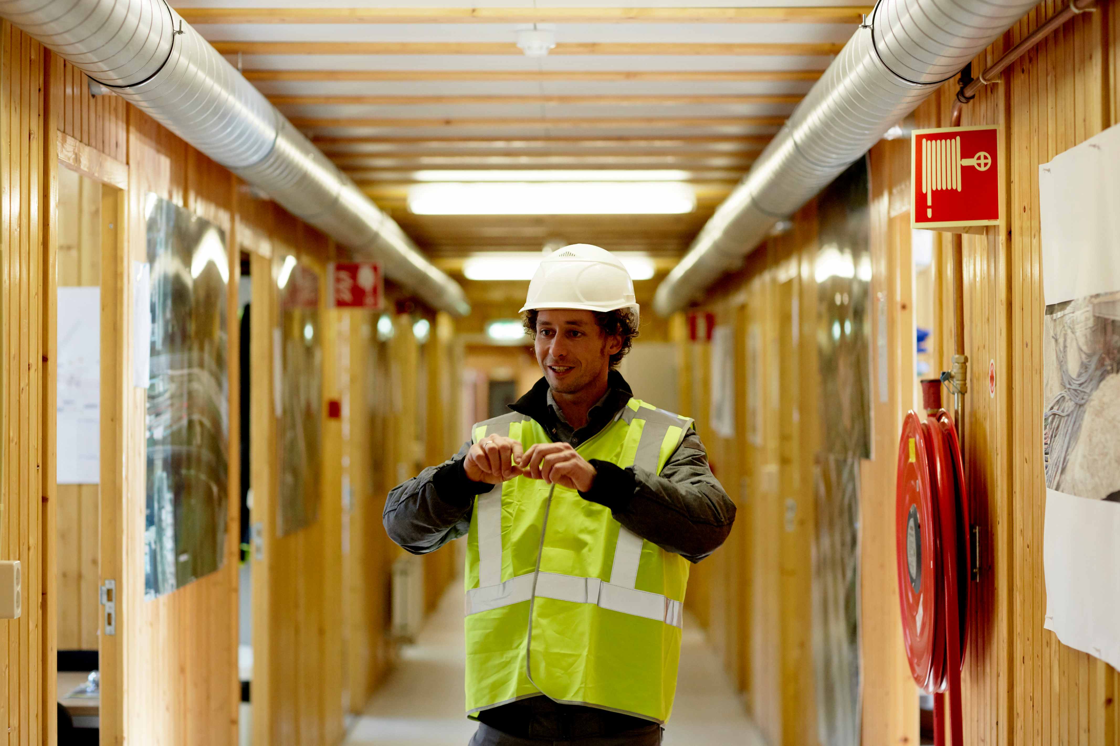 Man in bouwwerf met helm op