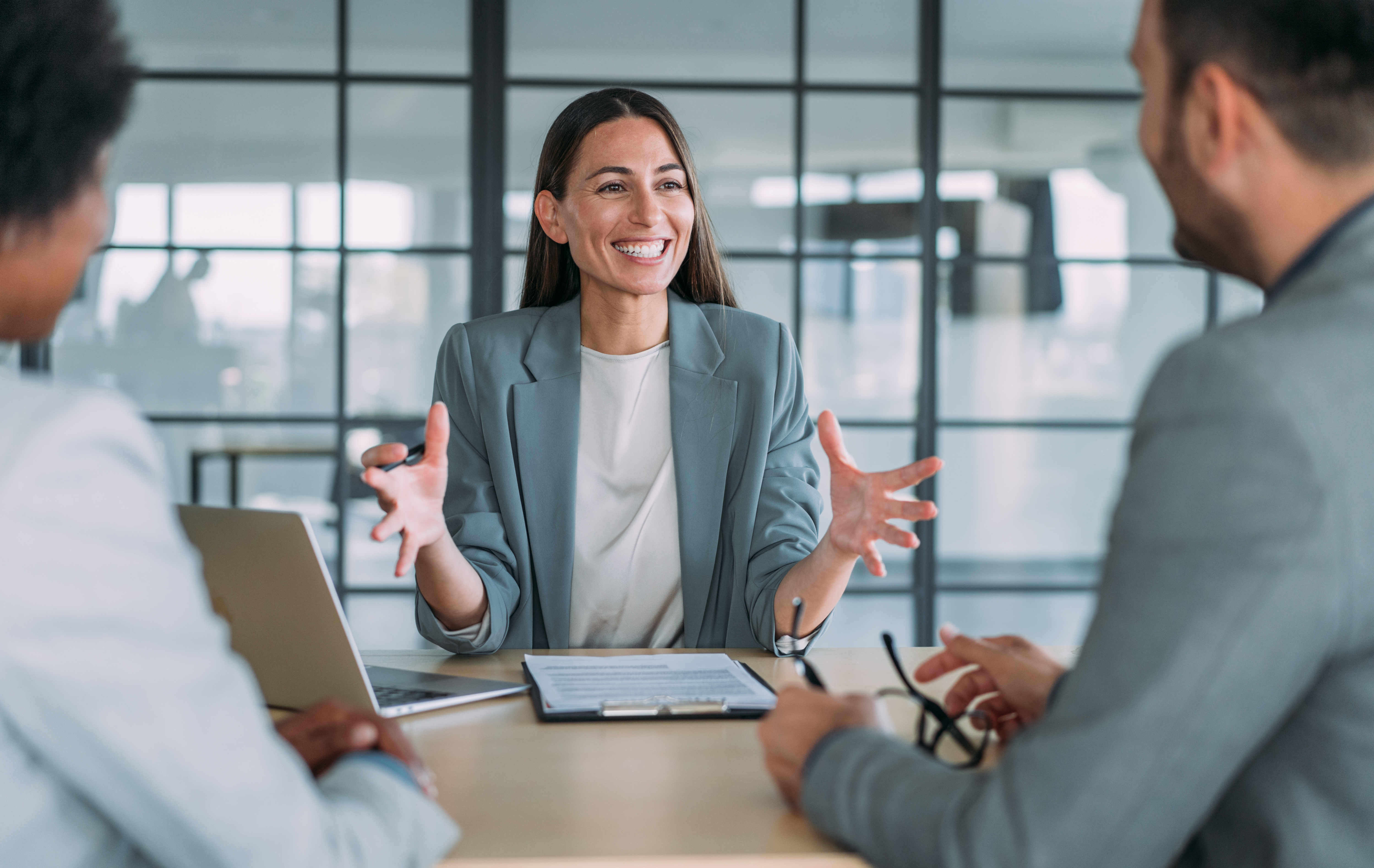 3 Personen im Business Gespräch an einem Tisch