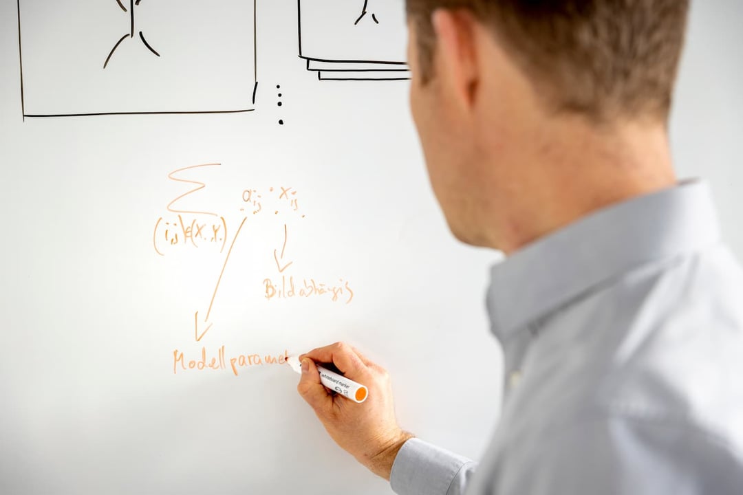 Man writing data on whiteboard