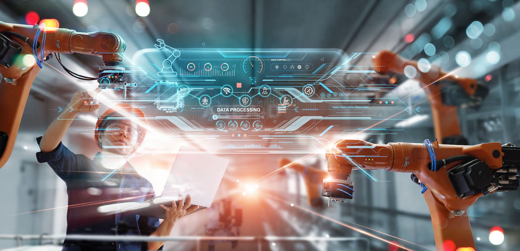 Worker in high tech factory working with robot arms
