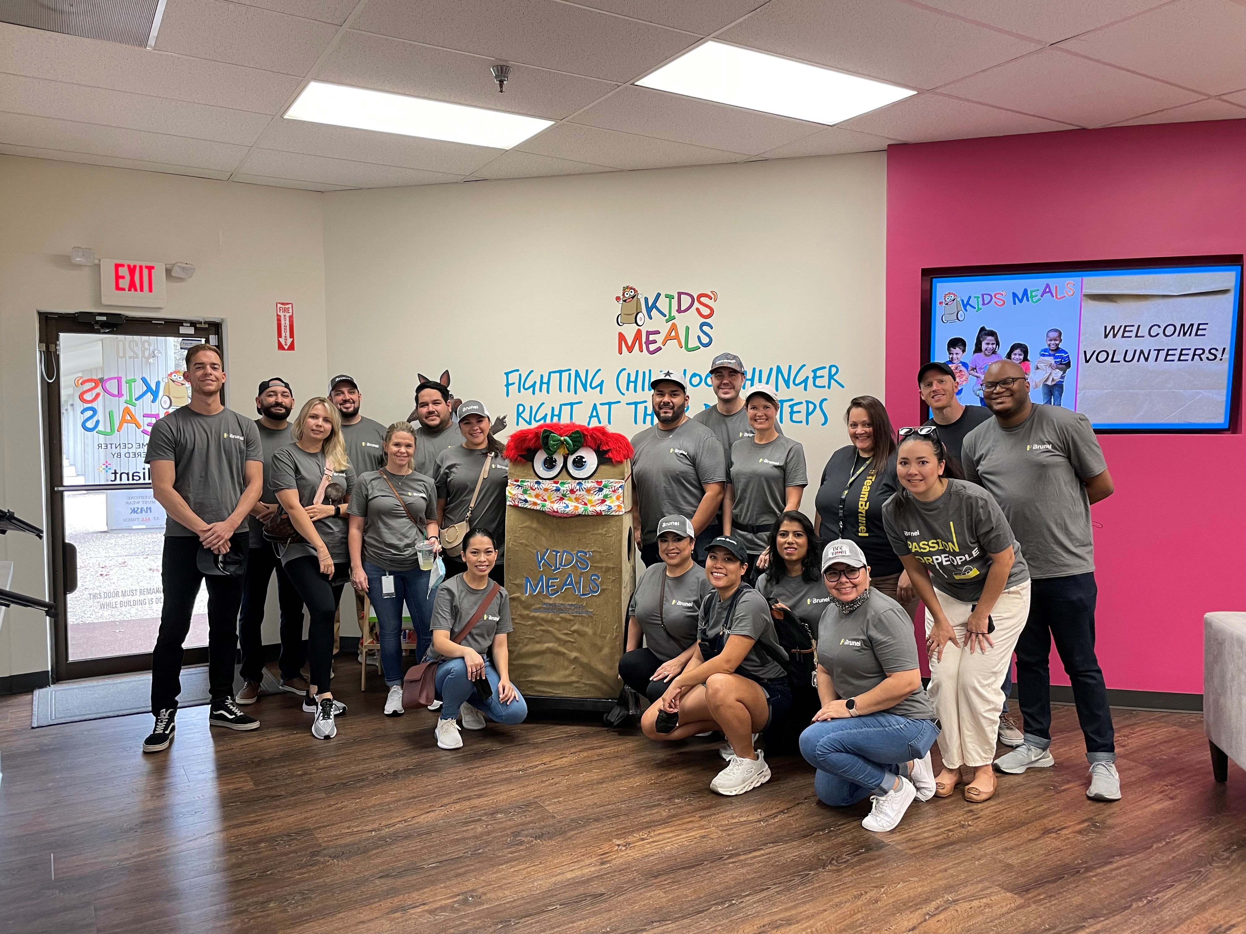 Impact from the heart: Brunel employees posing inside the Kids Meals center after preparing meals for children in need.