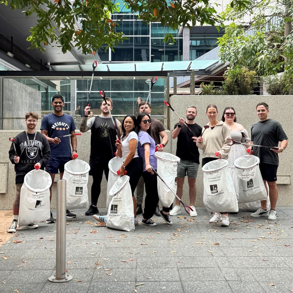 Brunel Volunteers Cleanup- Trash 'n Trace Brunel volunteers holding litter pickers and large trash bags during an urban cleanup activity.