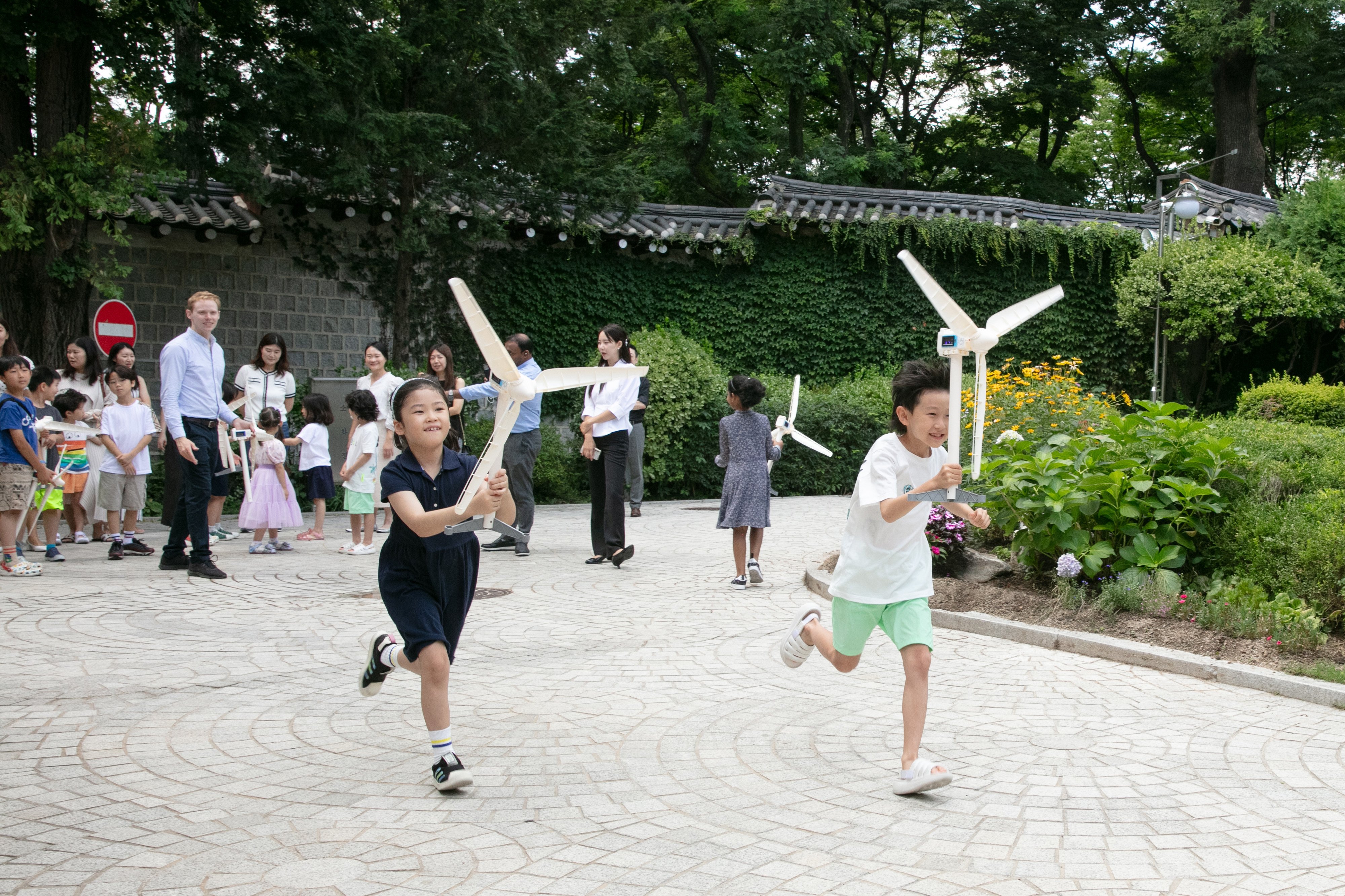 Brunel Foundation Renewable Energy Offshore4kids Workshop Children running outdoors with wind turbine models during a Brunel Foundation Offshore4kids sustainability activity.