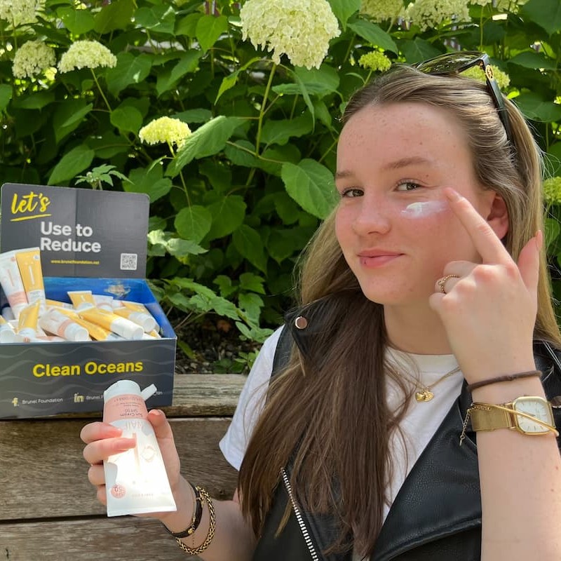 Girl putting on plastic free sunscreen on her face