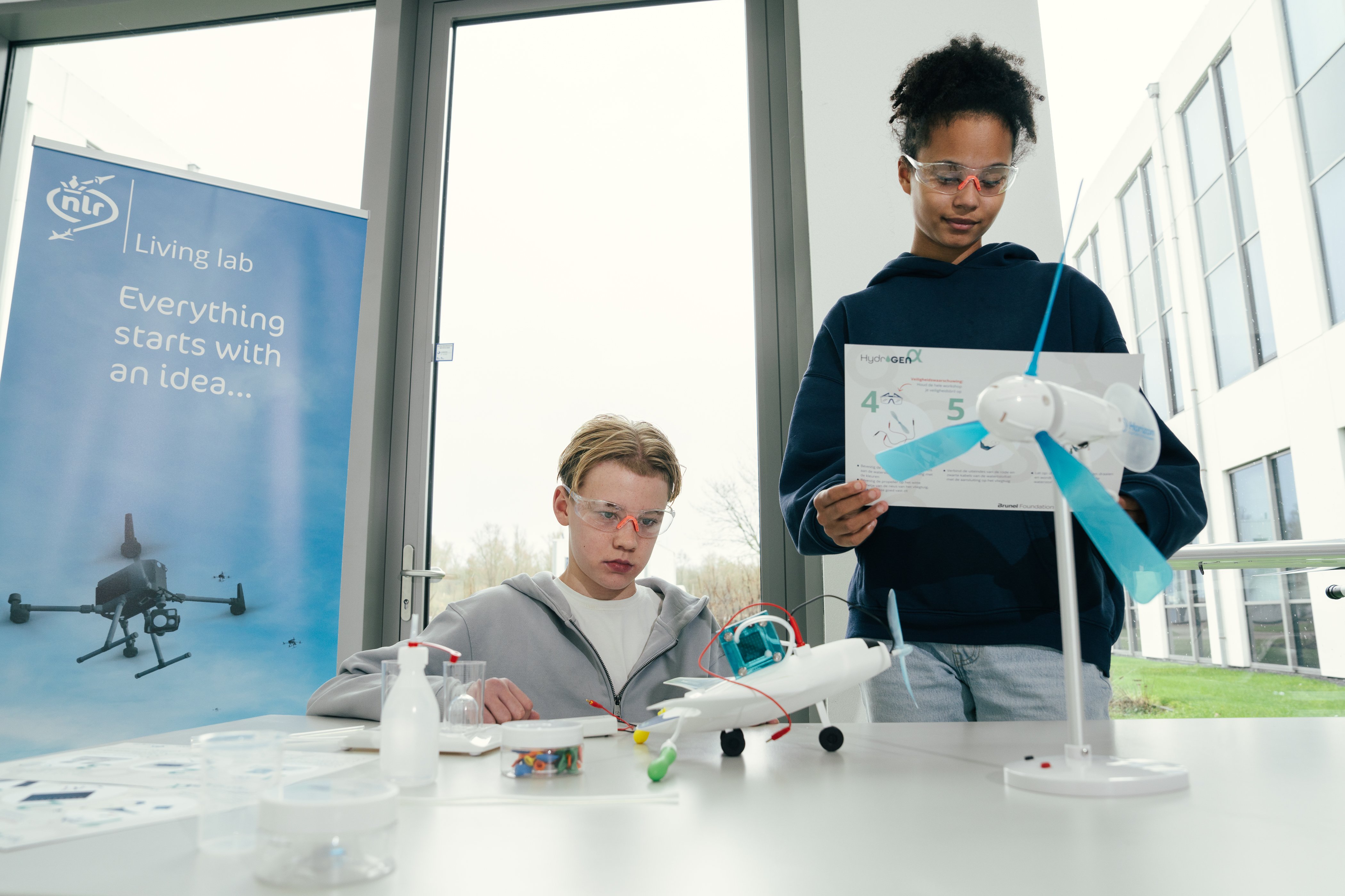 Kids present a hydrogen-powered model aircraft and wind turbine during the HydrogenAlpha workshop by the Brunel Foundation.
