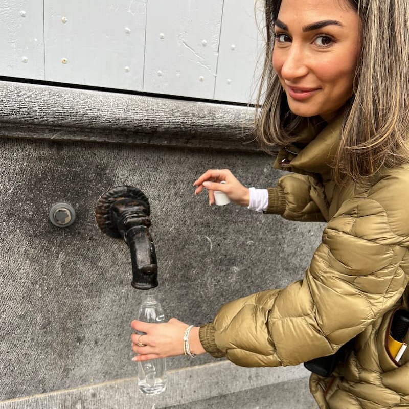 Woman filling sustainable water bottle