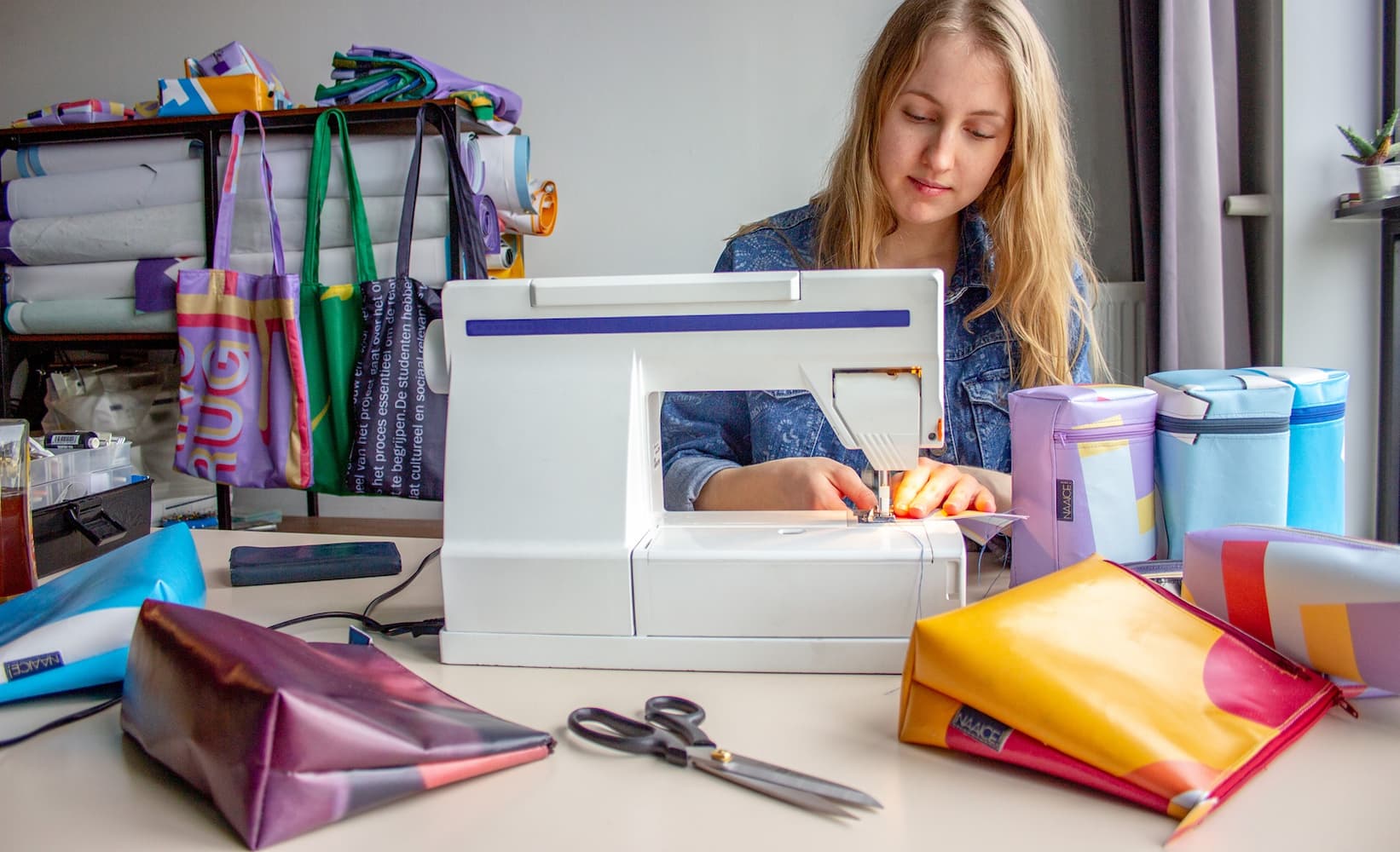 Woman with sewing machine working on recycling products