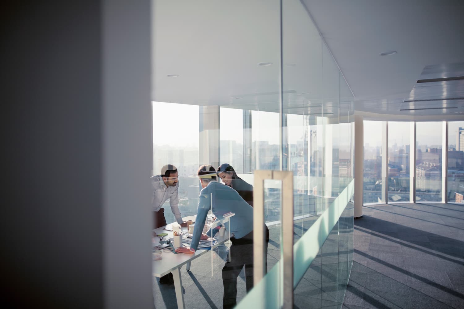 People standing at a table in an office with wide view