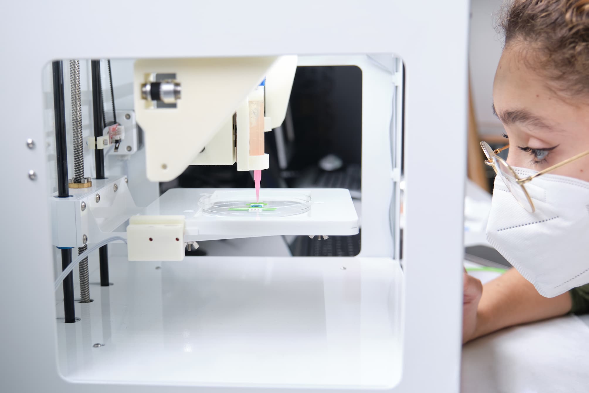 Woman in lab looking at bioprinting machine