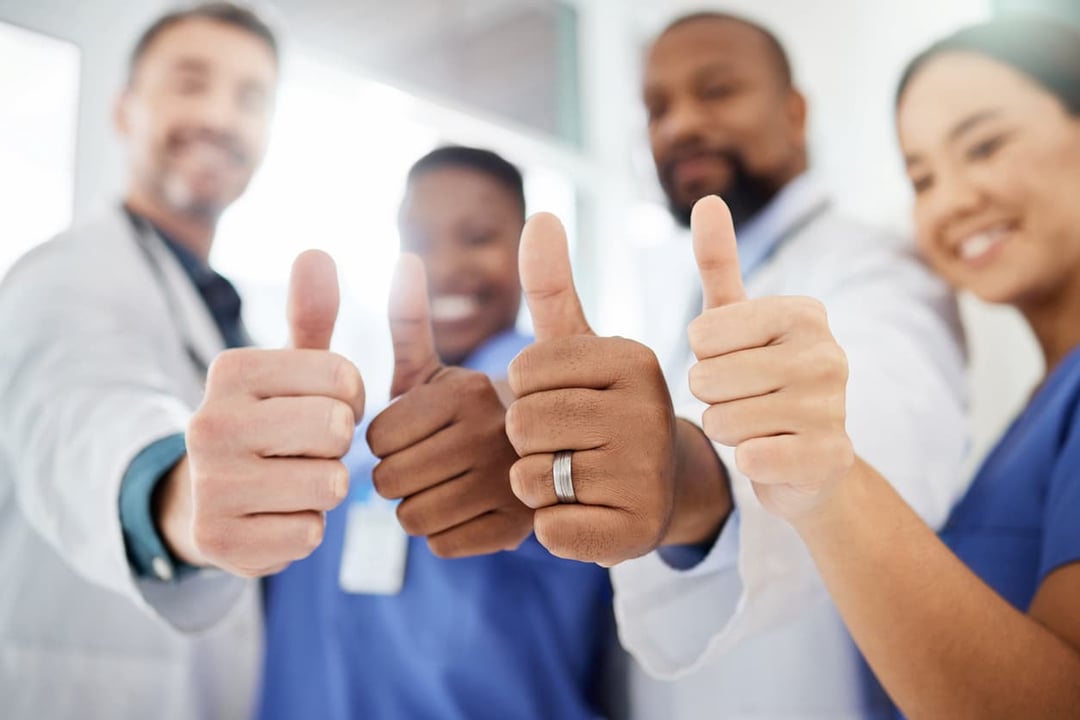 Group of happy employees giving thumbs up signs